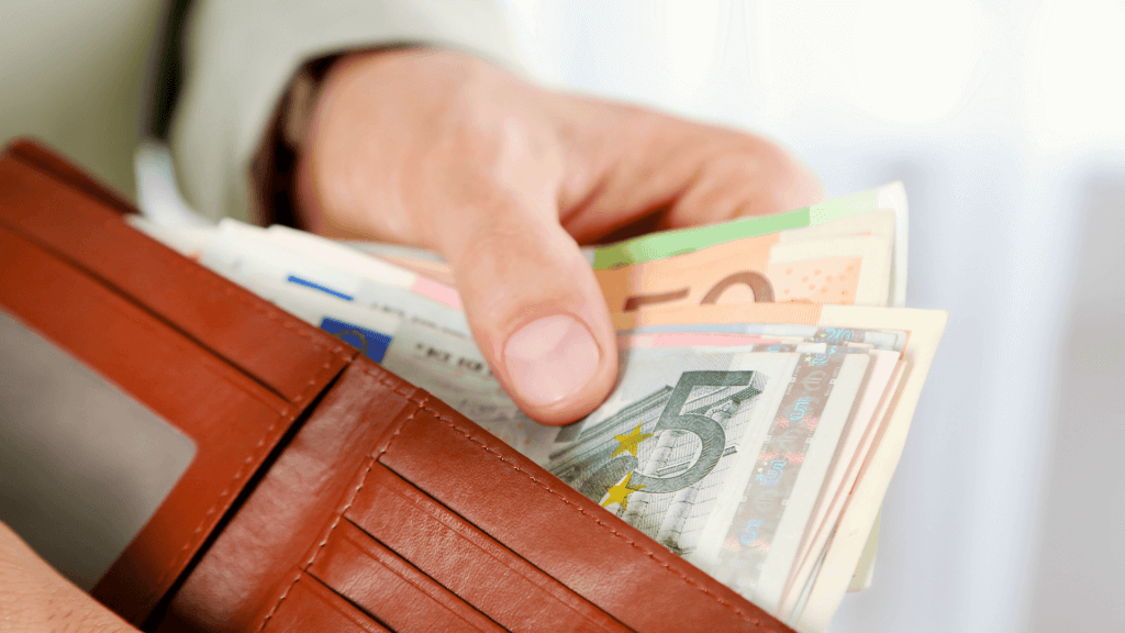 Homme qui sort des billets de banque de son porte monnaie