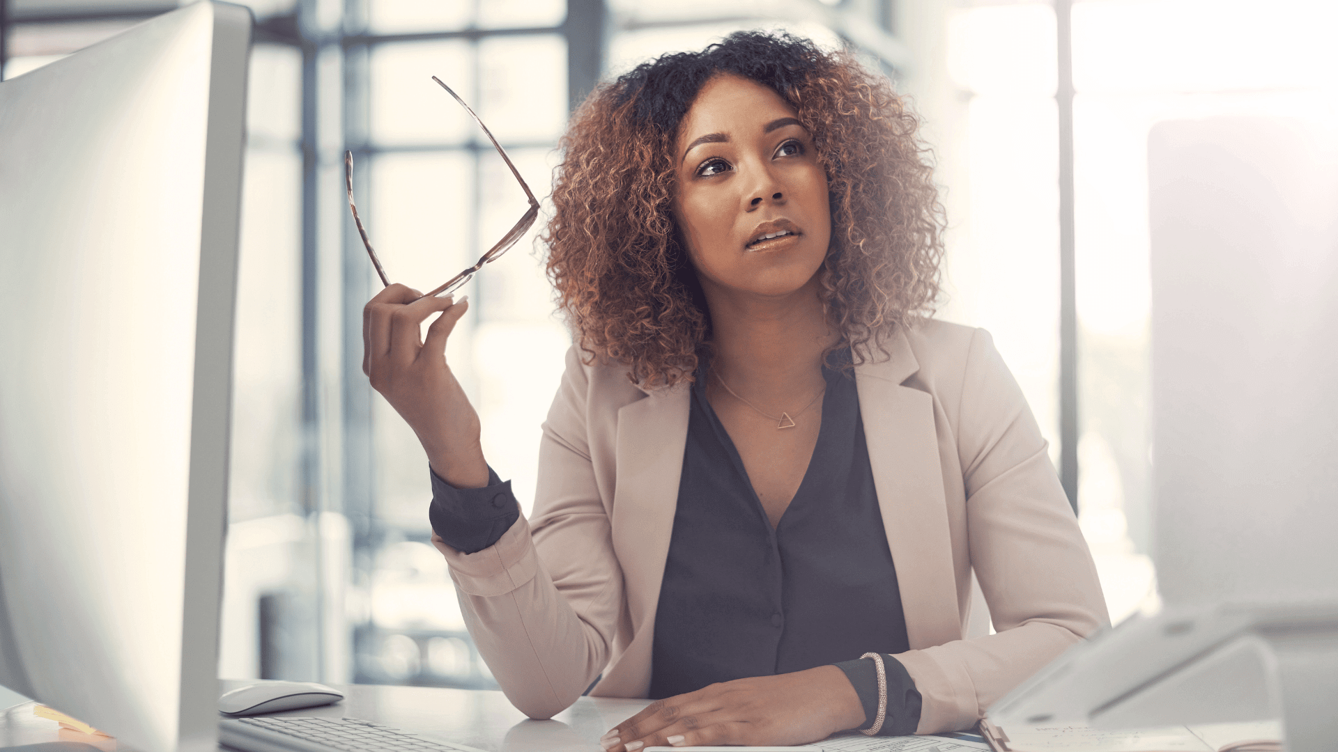 Femme noire pensive qui se demande qu'elle est la définition du bilan de compétences